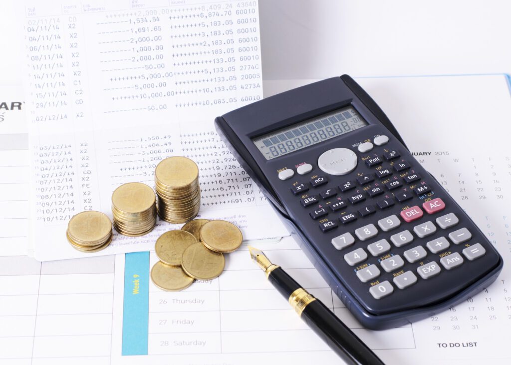 Calculator and money coins stack with fountain pen for finance